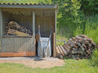 Hütte mit Brennholz und Scheibtruhen